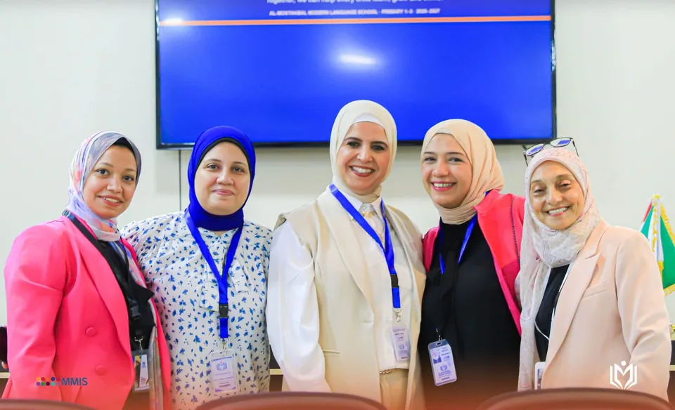 خمس من فريق المدرسة أمام شاشة العرض