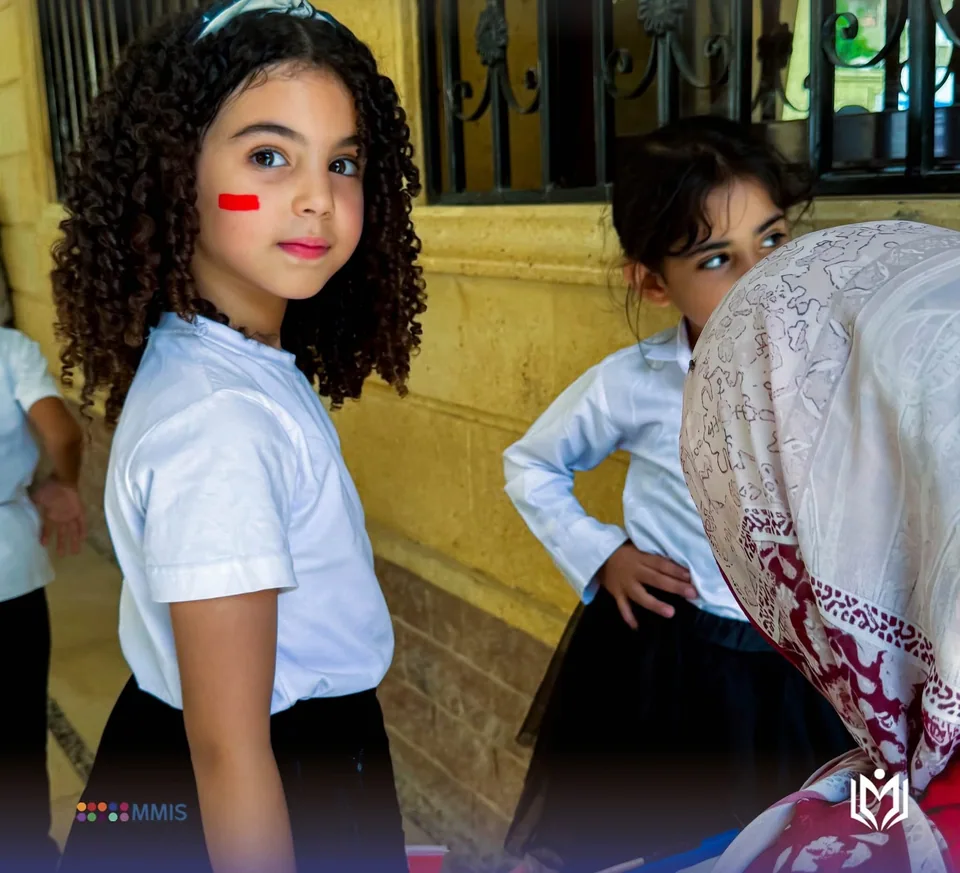 طالبة بالزي المدرسي مرسوم على خدها خط أحمر